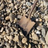 Pile of 1-3 inch Delaware River stones with a metal shovel lying on top